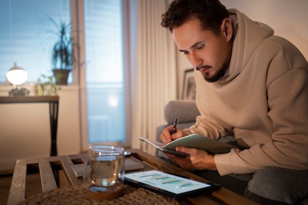 A young person using a smartphone app that visualizes their budget and savings goals with charts and graphs, set against a contemporary living space.