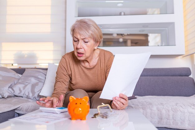 A stressed gig worker surrounded by bills and financial documents, highlighting the challenges of managing finances and saving for retirement in an unstable income environment.
