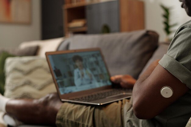 A doctor conducting a virtual consultation with a patient regarding their diabetes management, using a remote monitoring device to track their blood sugar levels.