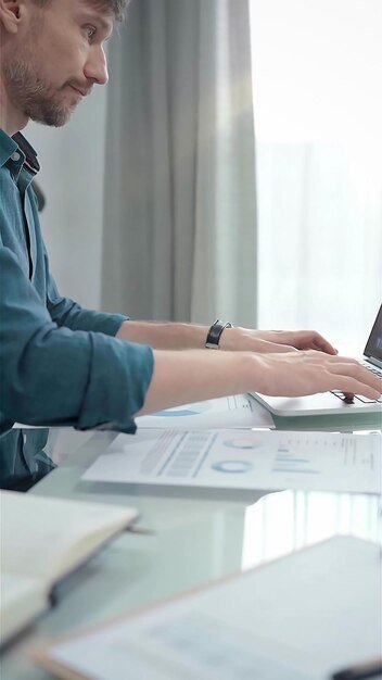 A person sitting at a desk with a laptop, reviewing financial documents and using a calculator, with a focus on healthcare cost projections.