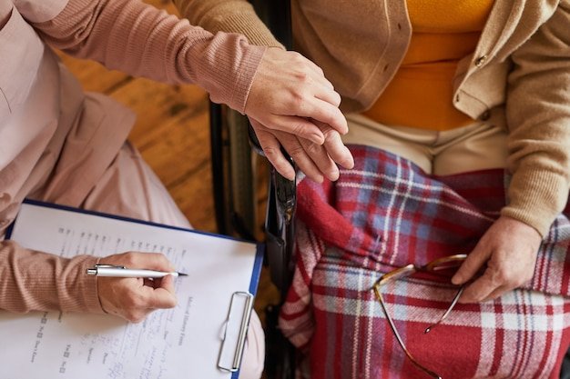 A caregiver assisting an elderly person with daily activities in a comfortable home setting, highlighting the need for long-term care.