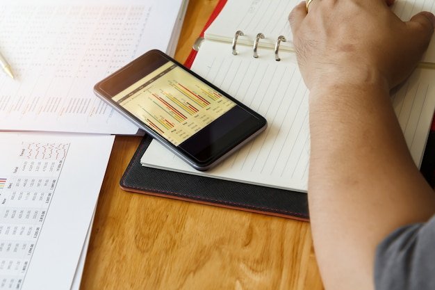 A person using a budgeting app on their smartphone, with a visual representation of how healthcare costs fit into the overall monthly budget.